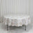 Round floral tablecloth on oval dining table in a minimal white room