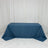 Blue tablecloth draped over a table against a plain backdrop.