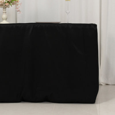 Black tablecloth draped over a table in a styled setting.