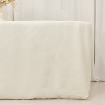Elegant white tablecloth draping over a table in a soft, neutral setting.