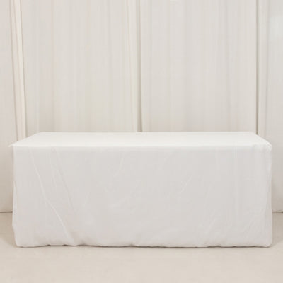 White table covered with a plain cloth in a studio setting.