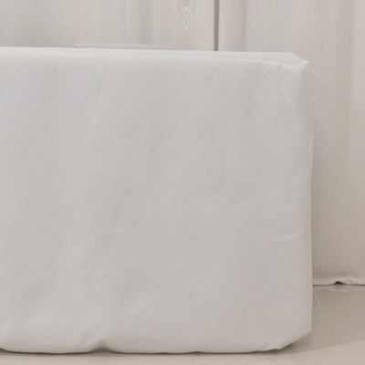 White table covered with a protective cloth in a minimalist setting.