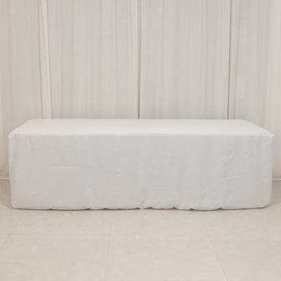 White table cover draped over a rectangular table in a studio setting