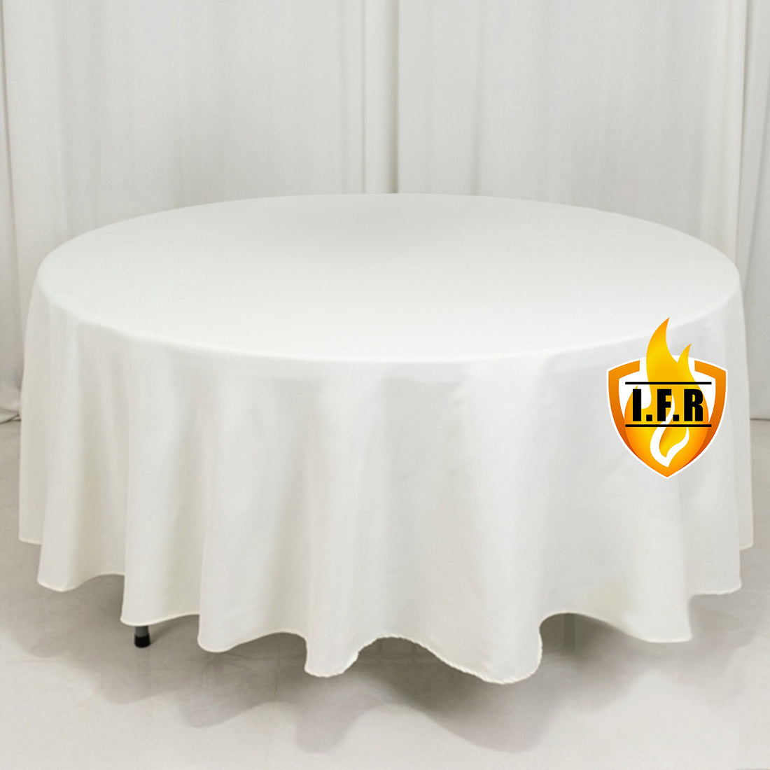 White round tablecloth on a table against a plain backdrop