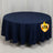 Navy round tablecloth on a table with a plain backdrop