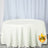 Round white tablecloth draping a table in a studio setting.
