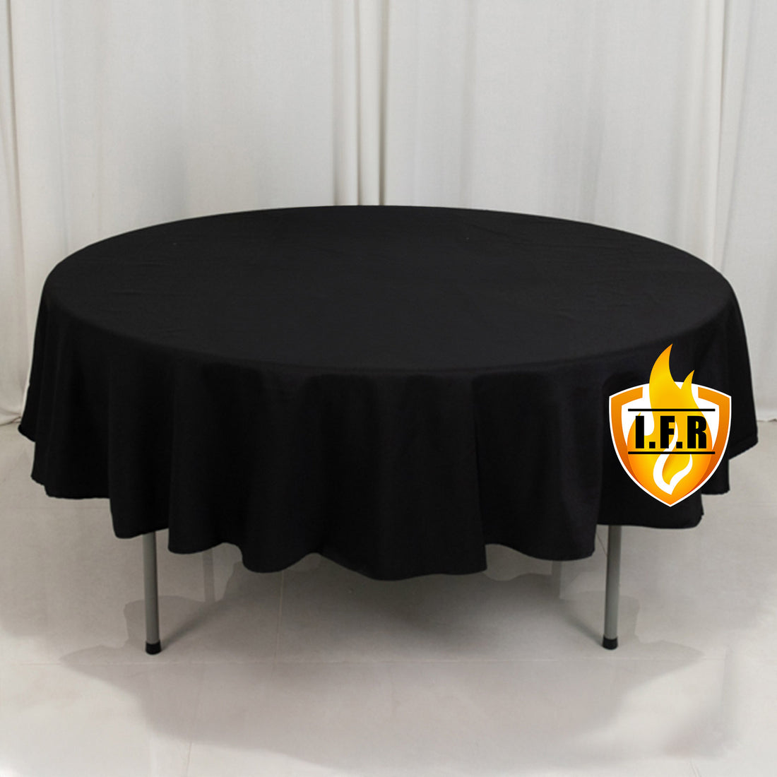 Round black table with tablecloth for events and gatherings.