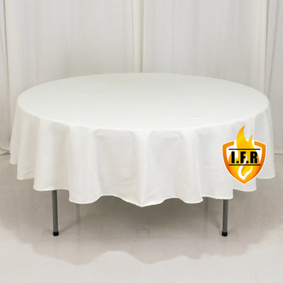 Round white table with a draped tablecloth.