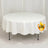 Round white table with a draped tablecloth.