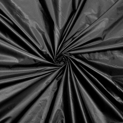 Black fabric with a glossy finish, displaying a spiral pattern.