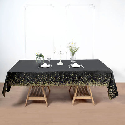 Black tablecloth with gold polka dots, elegantly draped on a wooden table.