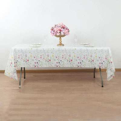 Floral pattern tablecloth on a dining table with a vase of flowers.