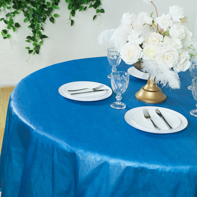 Elegant blue table setting with white roses and glassware.