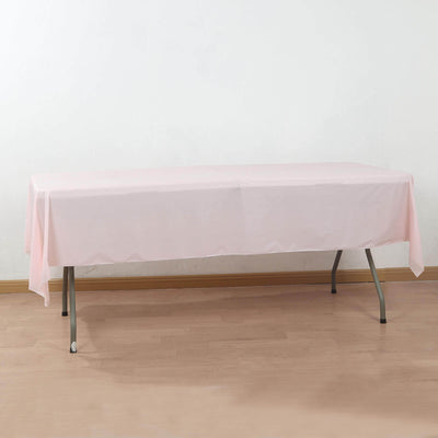Pink tablecloth draped over a folding table in a simple setting.