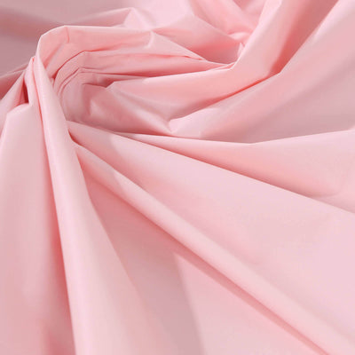 Pink fabric draped in soft folds and creases.
