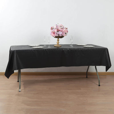 Elegant black tablecloth set on a table with floral centerpiece and dinnerware.