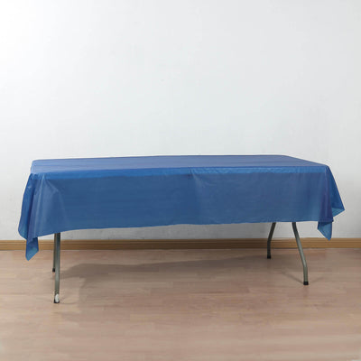 Blue tablecloth draped over a folding table on a light wood floor.