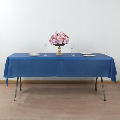 Blue tablecloth draped over a table with floral centerpiece and glassware.
