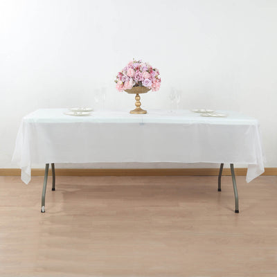 Elegant white tablecloth draped over a table with a floral centerpiece.