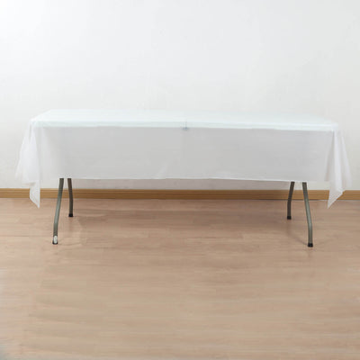 White table covered with a plain tablecloth in a minimalist setting.