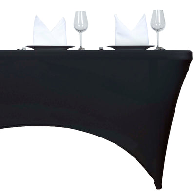 Black fitted table cover with plates, glasses, and folded napkins displayed.