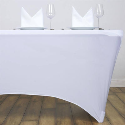 White tablecloth draped over a table set for dining with glasses and folded napkins.