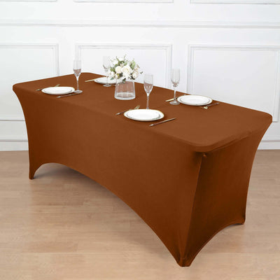 Brown fitted tablecloth on a dining table with plates and glasses.
