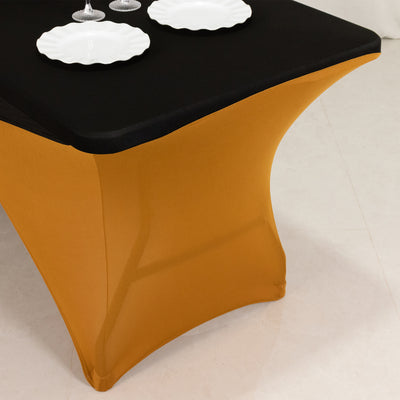 Stylish black and gold table cover with plates on a dining table.