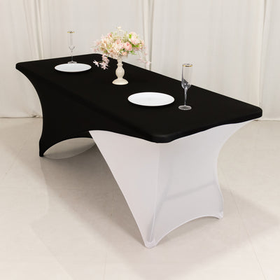 Elegant black and white table cover with floral centerpiece and tableware.