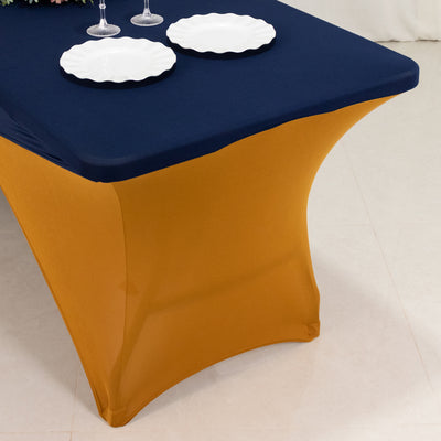 Table with a navy blue tablecloth and gold fitted skirt, elegantly styled for dining.