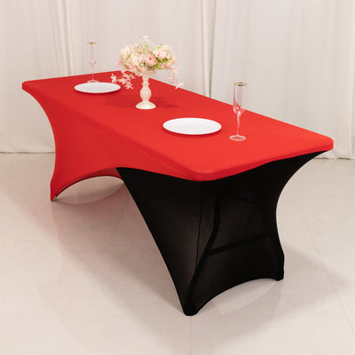 Red and black table cover with floral centerpiece and dinnerware in a styled setting.