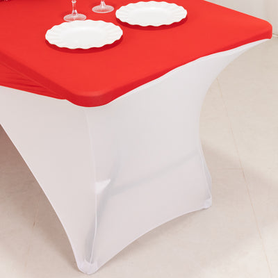 Red and white table cover with plates on a dining table.