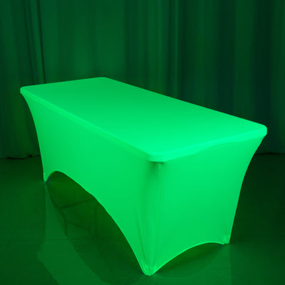 Green illuminated table cover in a studio setting.