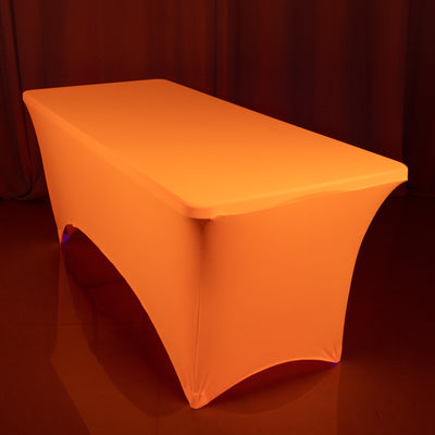 Orange table cover draped over a table in a studio setting.