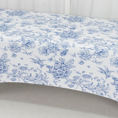 Floral print tablecloth in blue and white design on a plain backdrop.