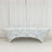 Floral-patterned table cover on a bench against a plain backdrop
