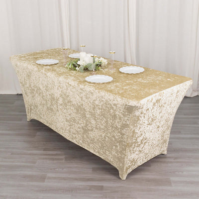 Gold textured tablecloth draped over a rectangular table with plates and decor.