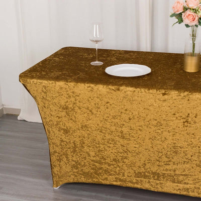 Gold velvet tablecloth draped over a table with a glass and plate on top.