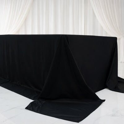Black table draped with fabric in a minimalist setting.