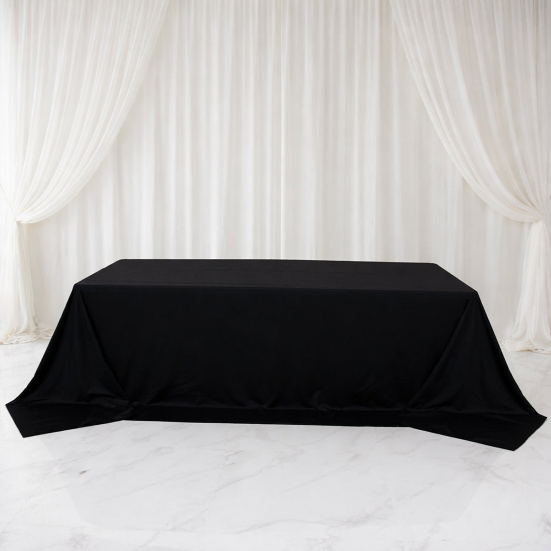 Black table cover draped elegantly over a table in a staged setting.