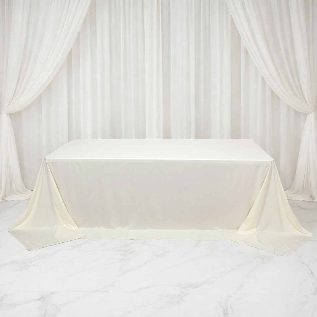 White tablecloth draped elegantly over a table in a studio setting.