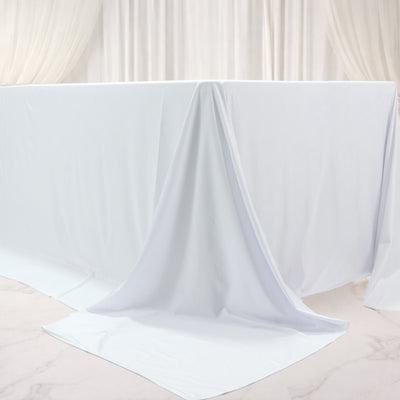 White table draped with smooth fabric, creating an elegant and clean look.