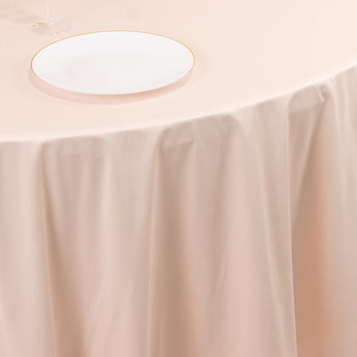 Elegant blush tablecloth draped over a table with a white plate on top.