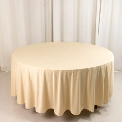 Round cream table with a draped tablecloth in a studio setting