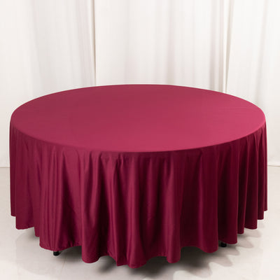 Round burgundy tablecloth draped over a circular table