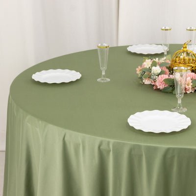 Elegant green tablecloth with white plates and floral centerpiece.