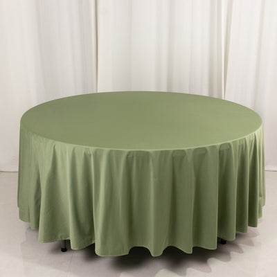 Round olive green tablecloth on a plain backdrop