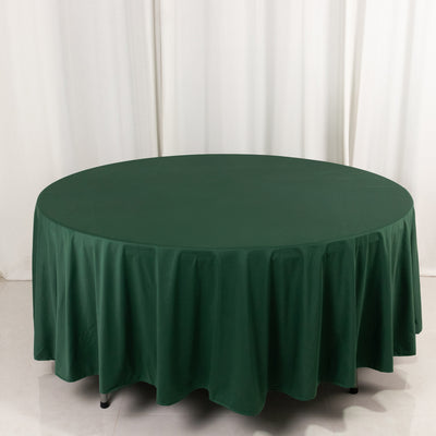 Green round tablecloth on a table against a light backdrop.