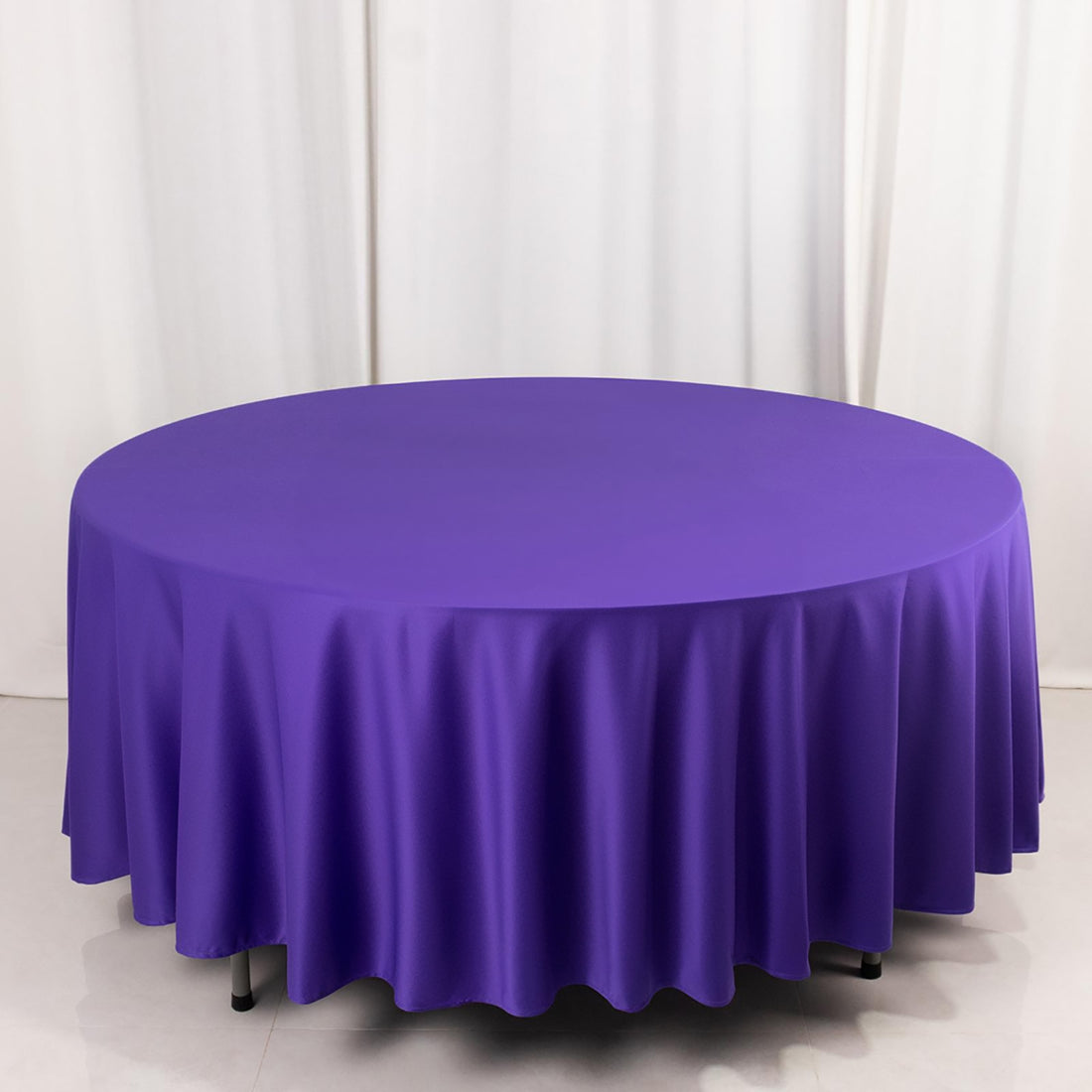 Purple round tablecloth on a plain backdrop