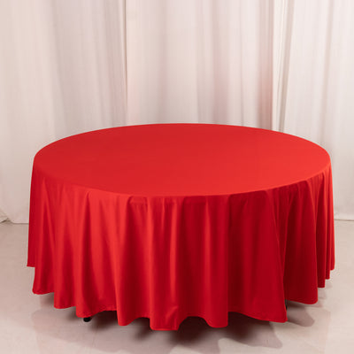 Round red tablecloth on a circular table in a studio setting.